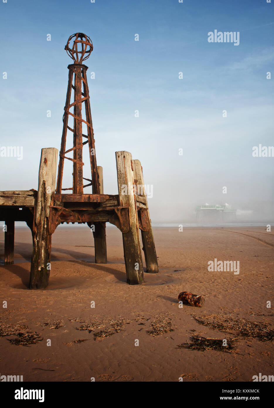 Two piers: the old pier is bathed in winter sunshine, with the newer Victorian pier barely discernible when obscured by fog Stock Photo