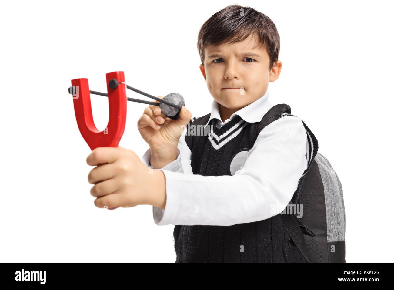 Angry little schoolboy aiming with a slingshot and a rock isolated on white background Stock Photo