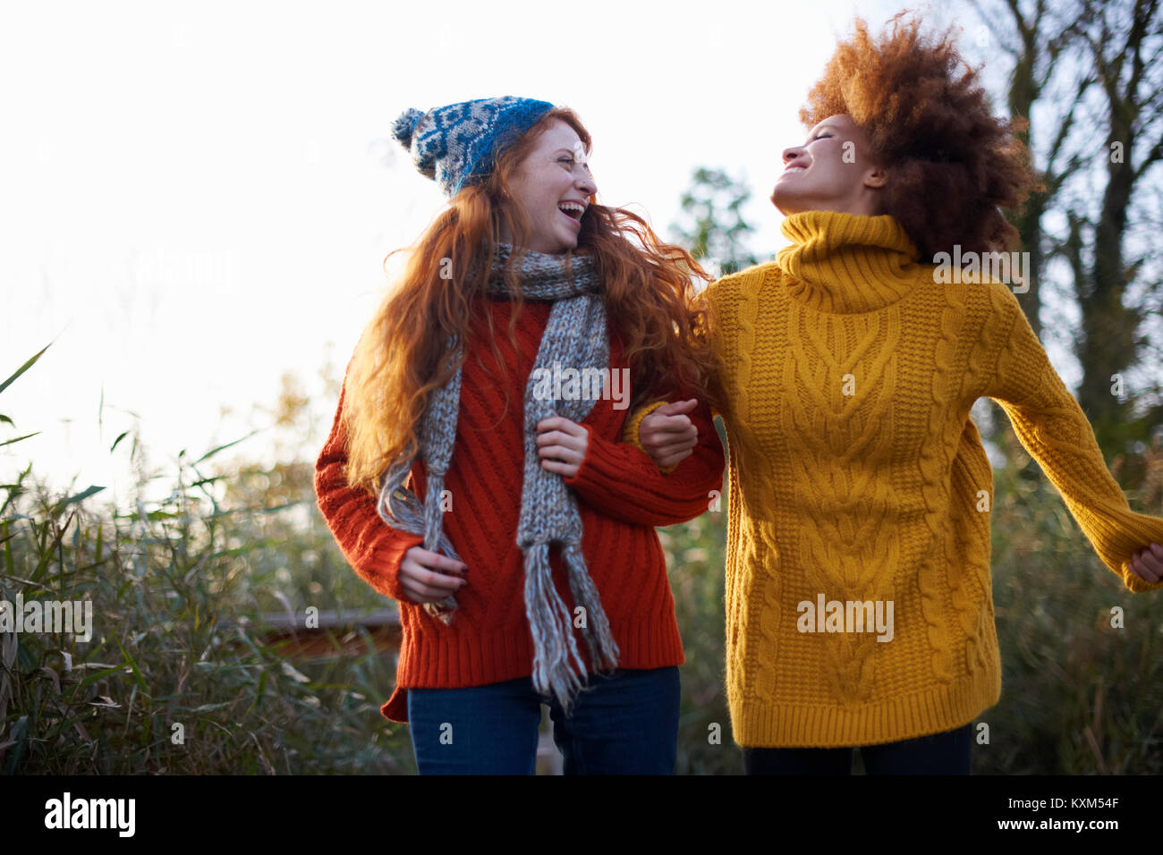 Friends arm in arm throwing head back laughing Stock Photo Alamy