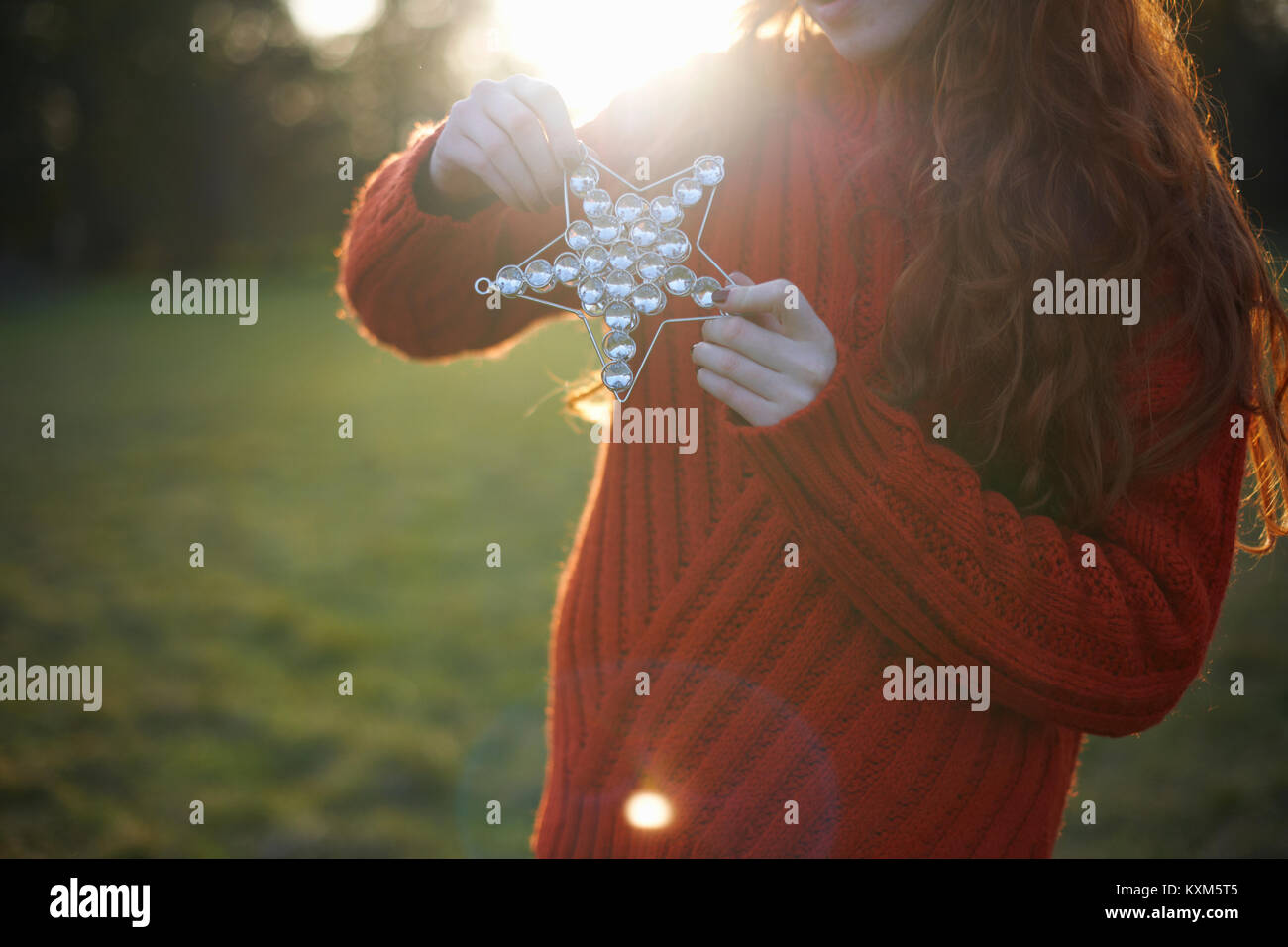 Young woman in rural setting,holding Christmas star,mid section Stock Photo