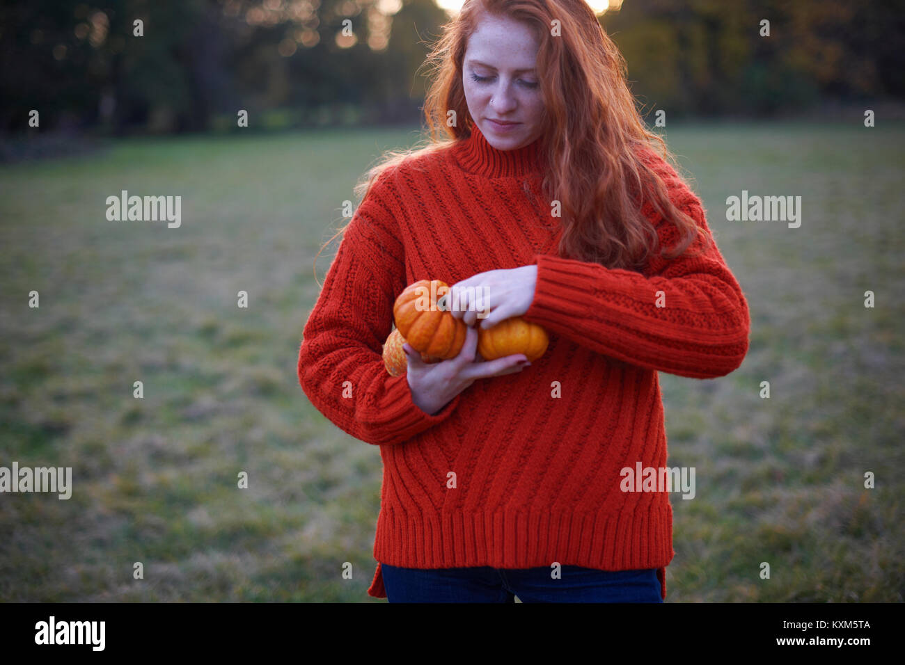 Young woman in rural setting,holding pumpkins Stock Photo