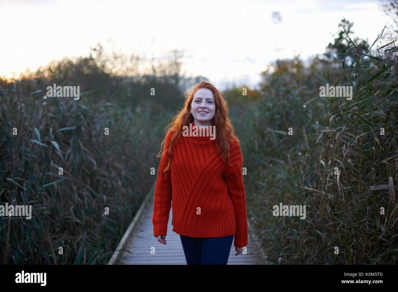 Portrait of young woman walking along rural pathway Stock Photo - Alamy