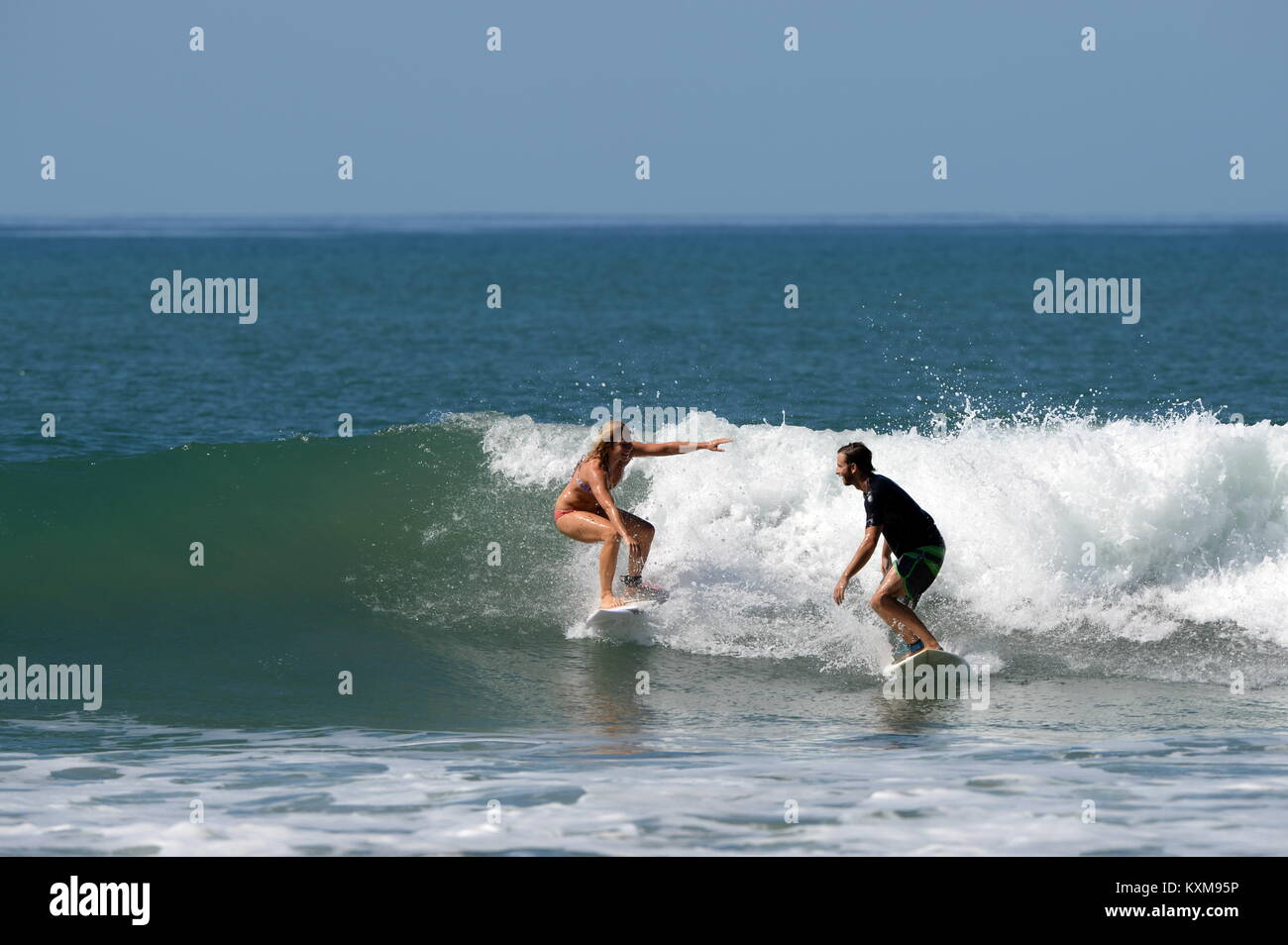 Surfing with a friend (sequence 2) in Costa Rica- newly engaged Denise and Kris share a wave together at Santa Teresa Stock Photo