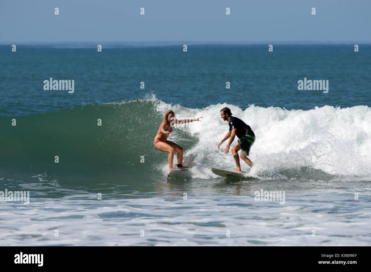 Surfing wth a friend (sequence 3)  in Costa Rica- newly engaged Denise and Kris share a wave together at Santa Teresa Stock Photo
