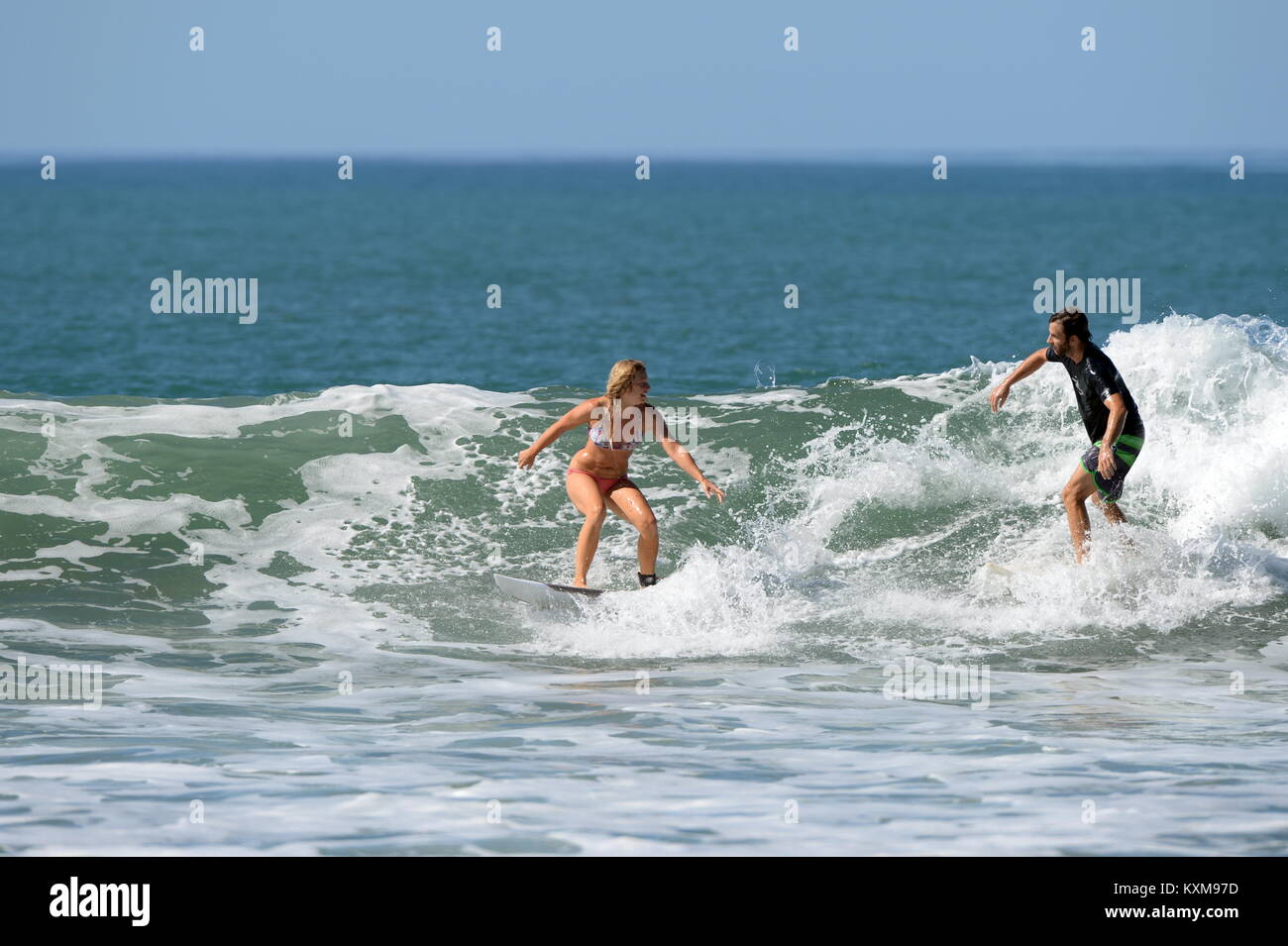 Surfing wth a friend  (sequence 4) in Costa Rica- newly engaged Denise and Kris share a wave together at Santa Teresa Stock Photo