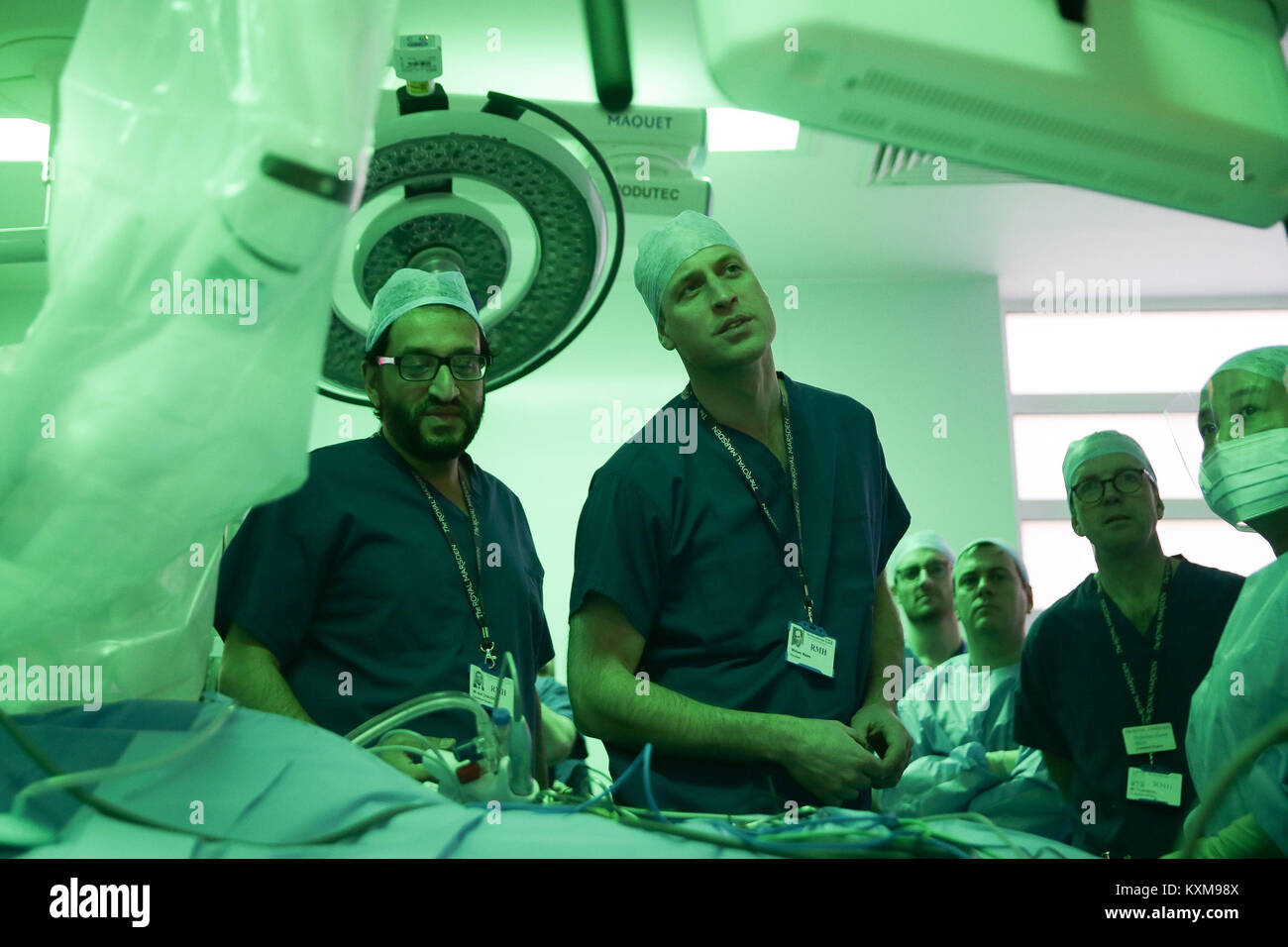 The Duke of Cambridge and lead surgeon Asif Chaudry (left) stand in front of a da Vinci XI machine prior to a highly complex robotic cancer operation to remove a tumour of the oesophagus at the junction between the heart, lungs and aorta of patient Charles Ludlow, 63, during his visit to the Royal Marsden NHS Foundation Trust in London. Stock Photo