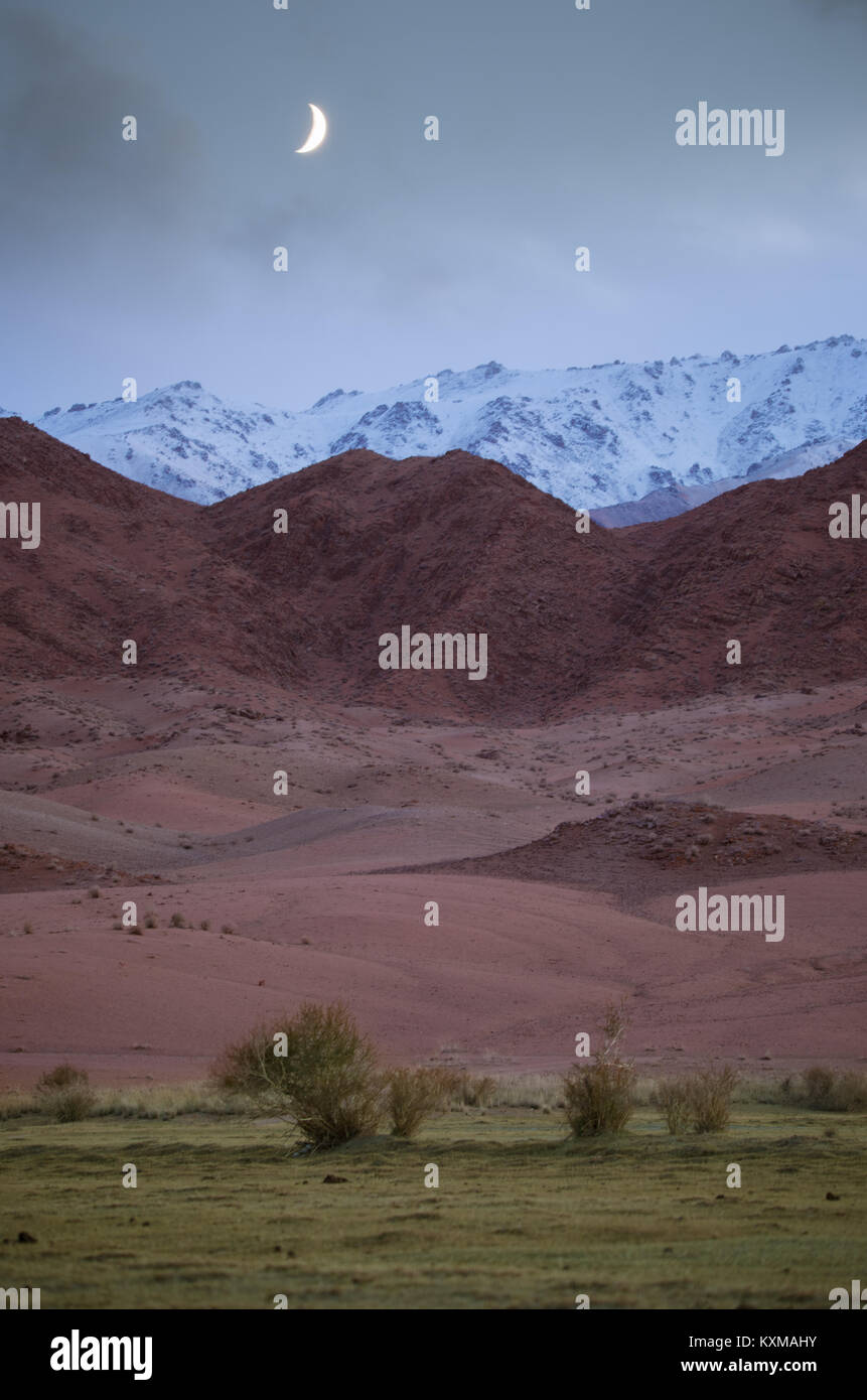 Mongolia landscape moon red white mountains dusk Stock Photo