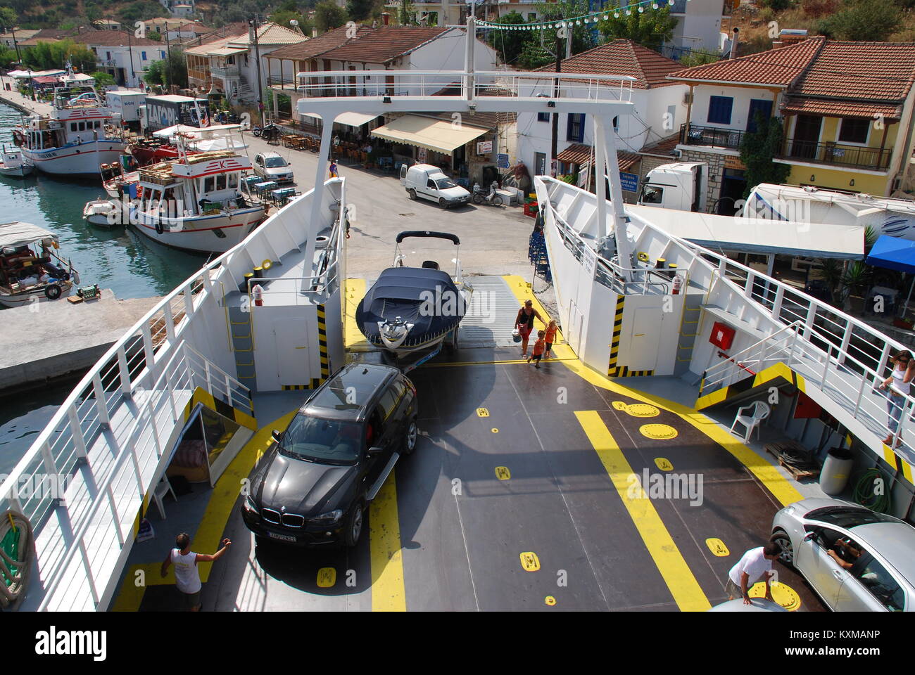 Passengers and vehicles embarking and disembarking from a ferry boat docked at Vathi harbour on the Greek island of Meganissi on August 28, 2008. Stock Photo