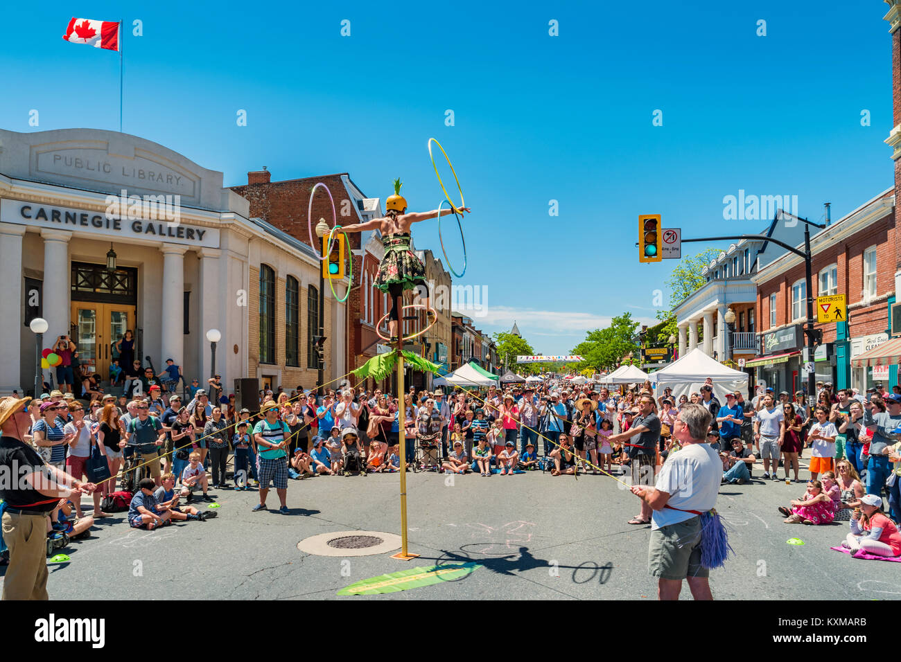 Crowd enjoys a busker show during the Buskerfest in downtown Dundas, Ontario, Canada on a sunny day. Stock Photo