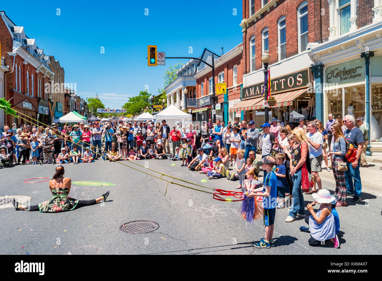 Crowd enjoys a busker show during the Buskerfest in downtown Dundas, Ontario, Canada on a sunny day. Stock Photo