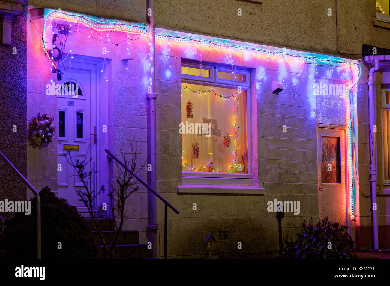 suburban house outside lights electric Christmas decoration windows and door Stock Photo