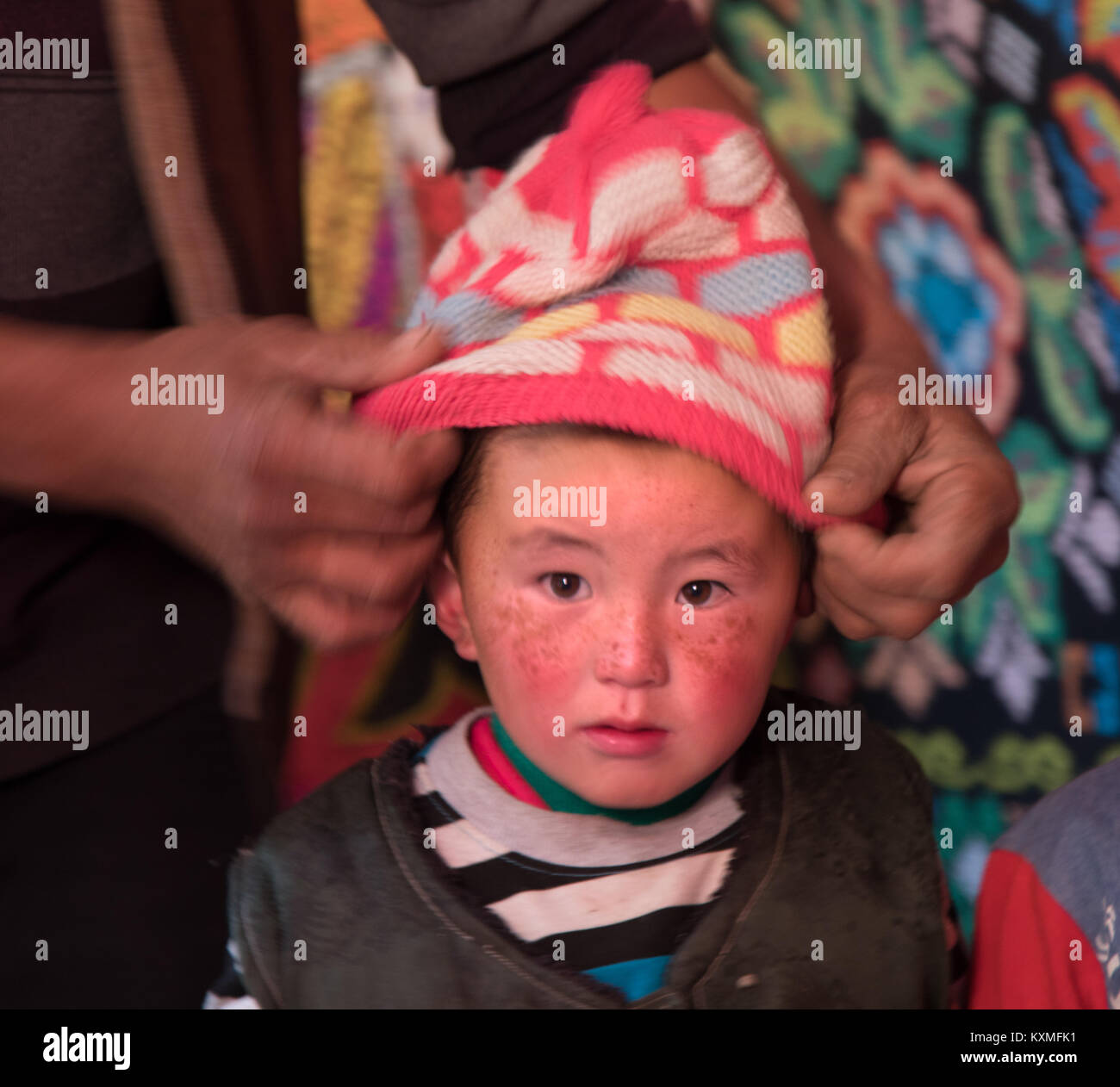 Rural country side little kid hat getting dressed preparing to go outside the ger cold winter Mongolia Stock Photo