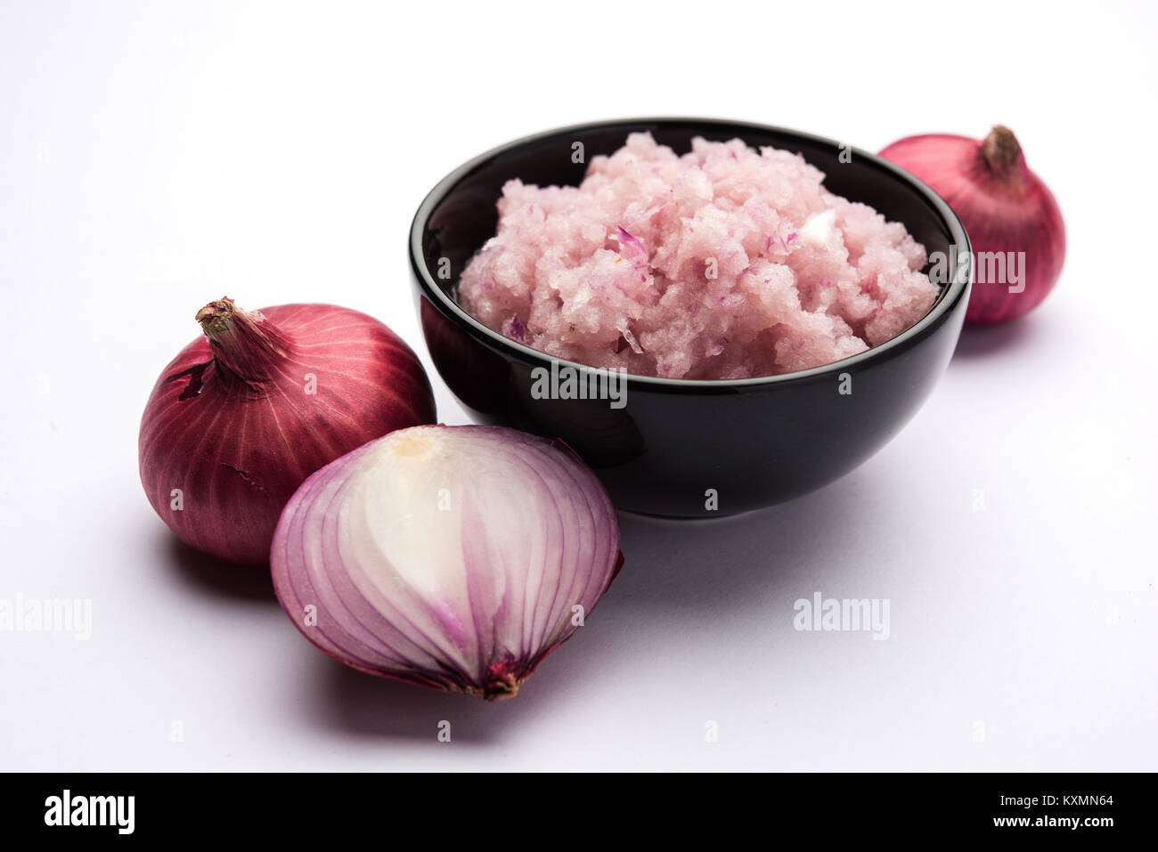 Onion Sauce or paste, in white or black ceramic bowl with raw cut onions, isolated over white background. Selective focus Stock Photo