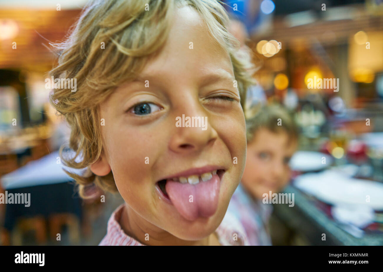 Portrait of boy looking at camera,poking out tongue Stock Photo