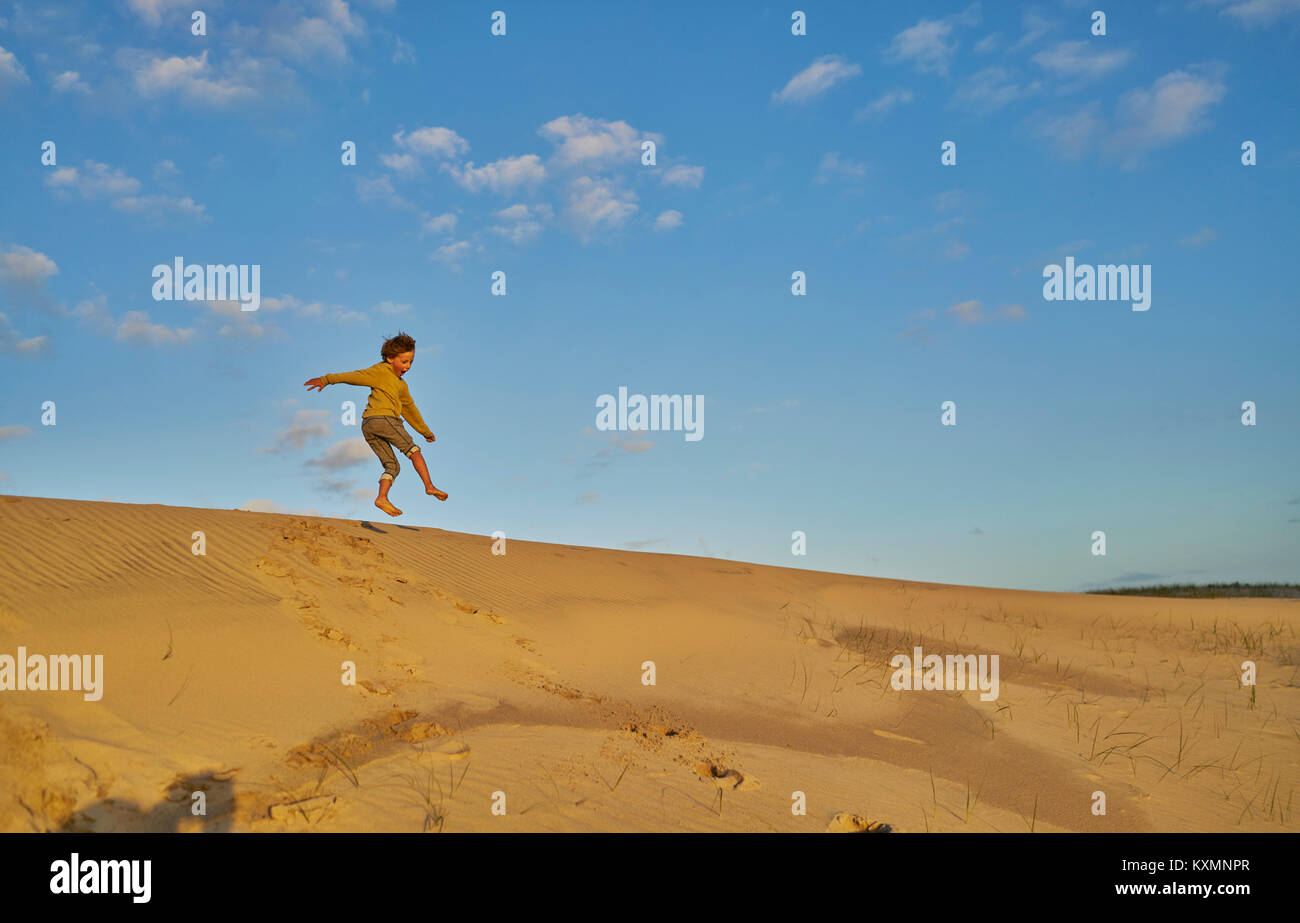 Boy in mid air jumping down dune,Polonio,Rocha,Uruguay,South America Stock Photo