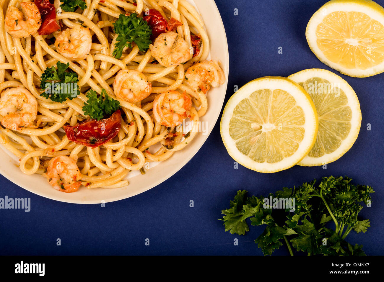 Italian Style Meal of King Prawn Bucatini Against A Blue Background Stock Photo Alamy