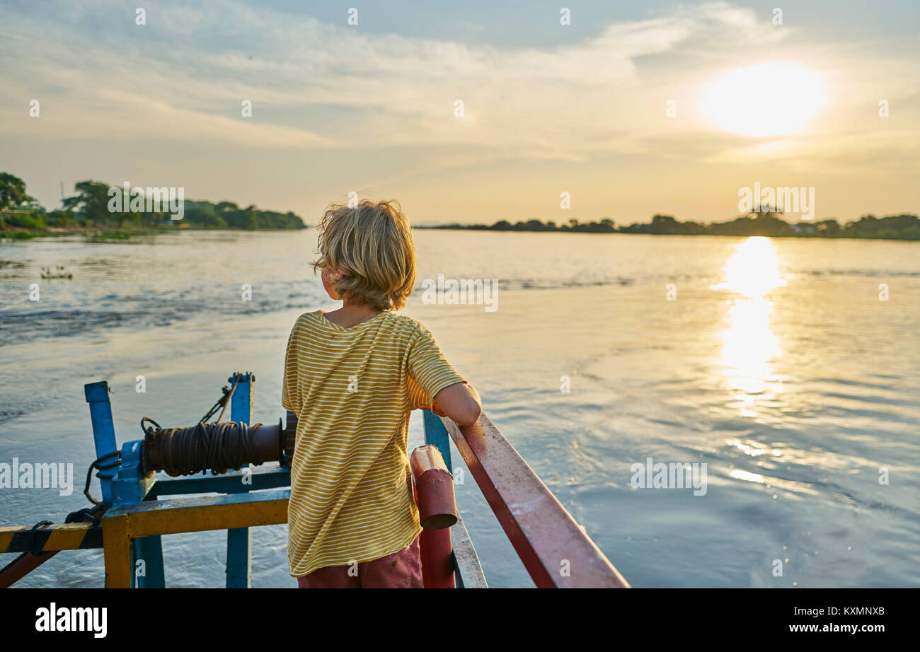 Boy looking away at view of sunset over lake,Bonito,Mato Grosso do Sul,Brazil,South America Stock Photo