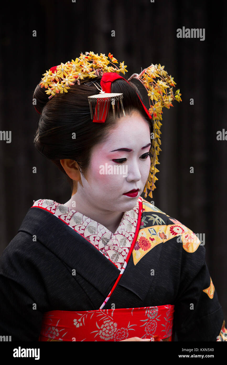 A geisha walks through the streets of Kyoto, Japan. Stock Photo