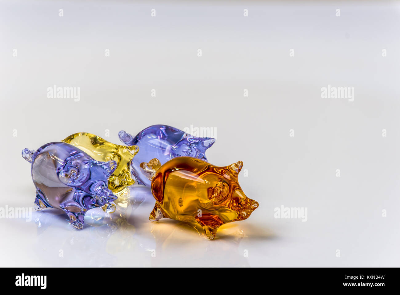 Cute glass pig figurines isolated on light background Stock Photo