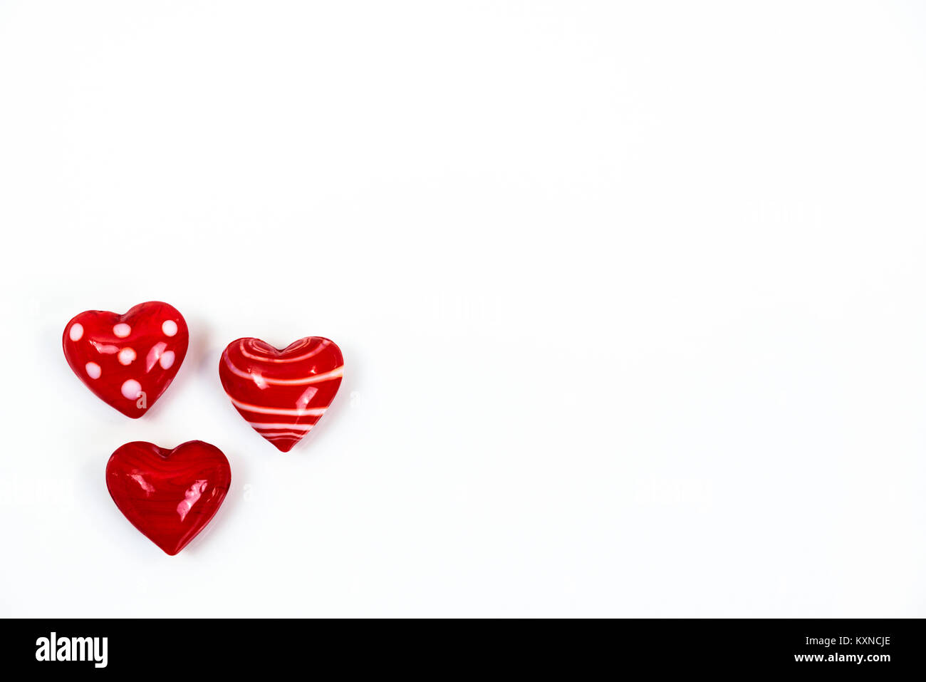 Small cute red heart figurines made of glass isolated on white background Stock Photo