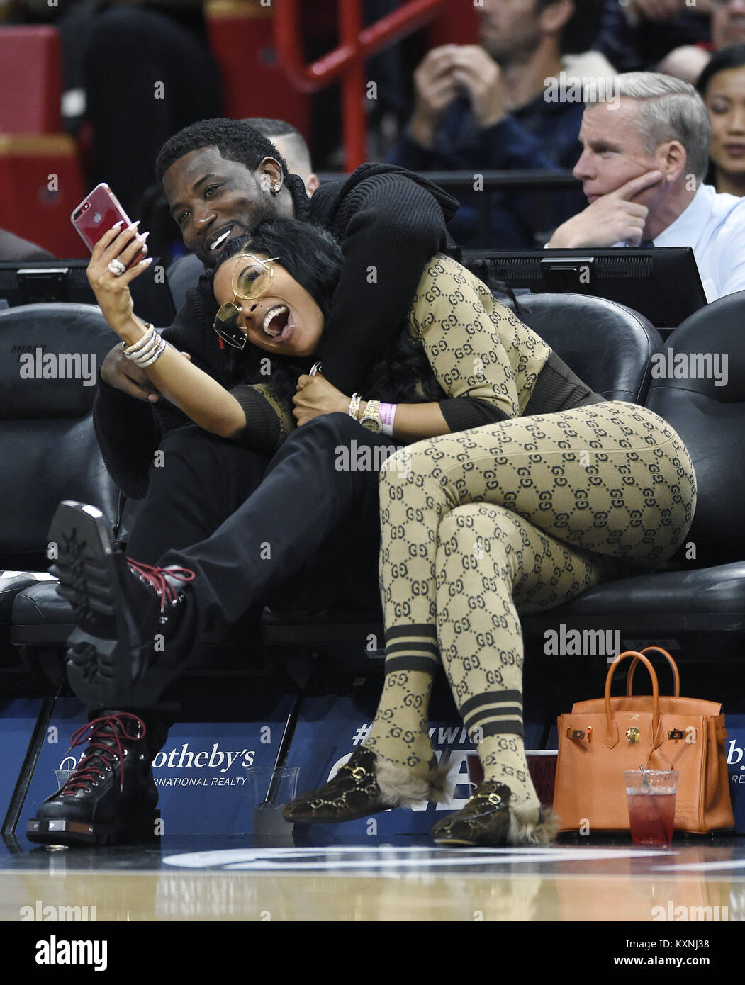 MIAMI, FL - JANUARY 5: Gucci Mane (L) and his wife Keyshia Ka'Oir (R) watch  the Miami Heat against the New York Knicks game at the America Airlines  Arena on January 5,