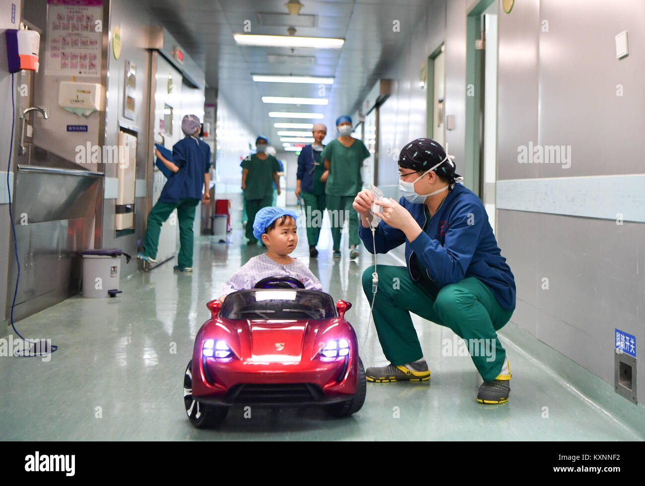 Changsha, China's Hunan Province. 11th Jan, 2018. A child sits a toy car listens to anesthetist Peng Tuochao in Hunan Children's Hospital in Changsha, capital of central China's Hunan Province, Jan. 11, 2018. Since October in 2017, the hospital started to allow children 'drive' toy cars to operating room in order to ease their nervousness before surgery. Credit: Xue Yuge/Xinhua/Alamy Live News Stock Photo
