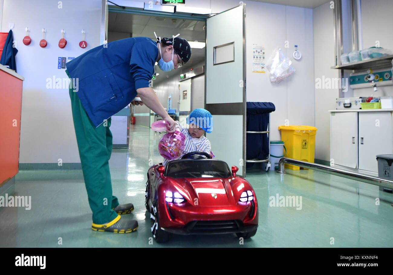 Changsha, China's Hunan Province. 11th Jan, 2018. Anesthetist Peng Tuochao gives sweets to a child in a toy car in Hunan Children's Hospital in Changsha, capital of central China's Hunan Province, Jan. 11, 2018. Since October in 2017, the hospital started to allow children 'drive' toy cars to operating room in order to ease their nervousness before surgery. Credit: Xue Yuge/Xinhua/Alamy Live News Stock Photo