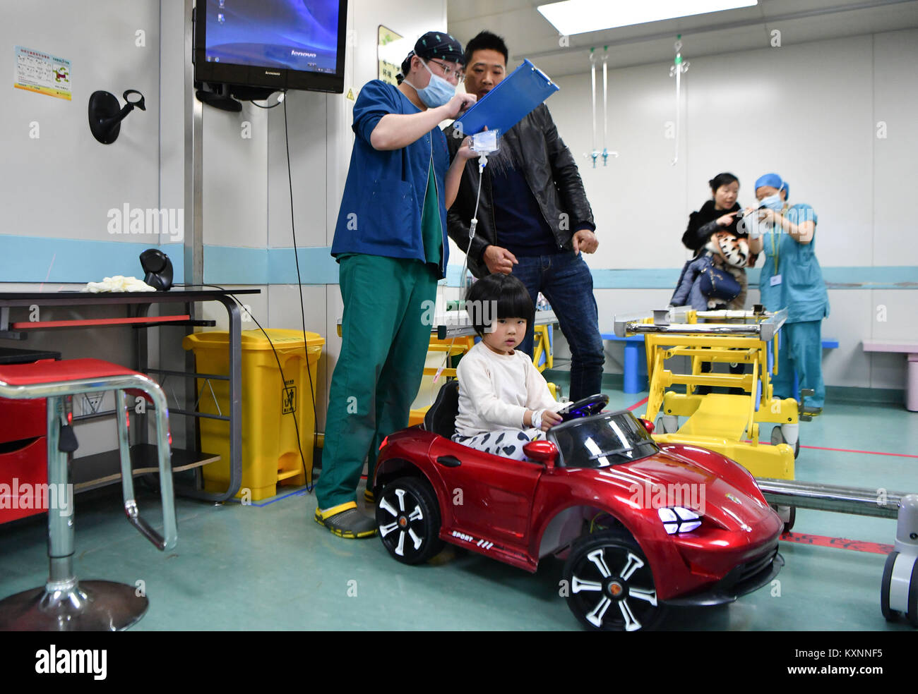 Changsha, China's Hunan Province. 11th Jan, 2018. A child sits a toy car as an anesthesiologist talks with her father in Hunan Children's Hospital in Changsha, capital of central China's Hunan Province, Jan. 11, 2018. Since October in 2017, the hospital started to allow children 'drive' toy cars to operating room in order to ease their nervousness before surgery. Credit: Xue Yuge/Xinhua/Alamy Live News Stock Photo