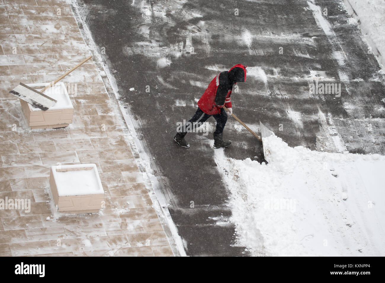 Moscow, Russia. 11th January, 2018.  Janitor shovel snow off the path in a residential area, in the city of Moscow during a heavy snowfall. Credit: Victor Vytolskiy/Alamy Live News Stock Photo