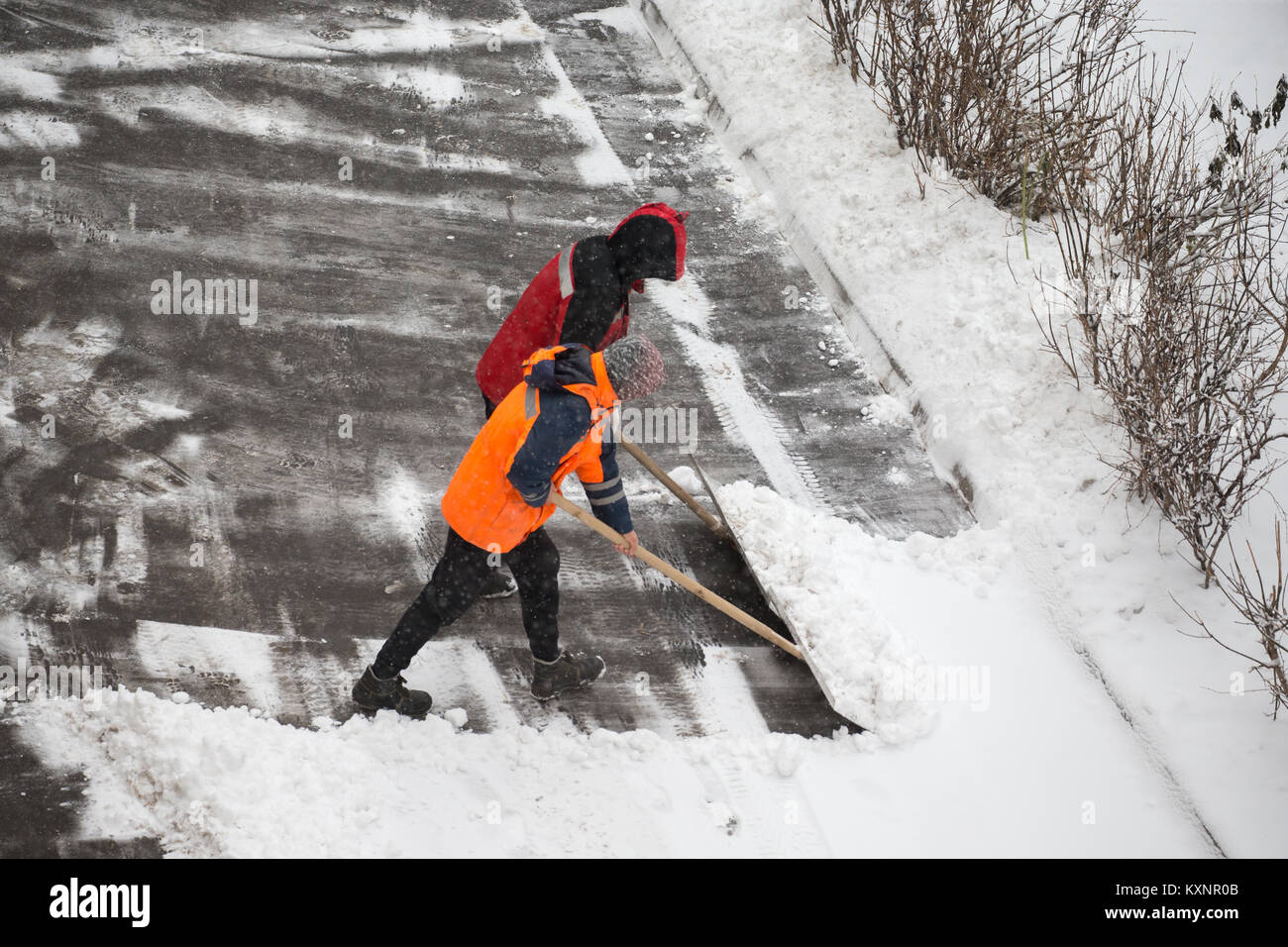 Moscow, Russia. 11th January, 2018.  Janitors shovel snow off the path in a residential area, in the city of Moscow during a heavy snowfall. Credit: Victor Vytolskiy/Alamy Live News Stock Photo