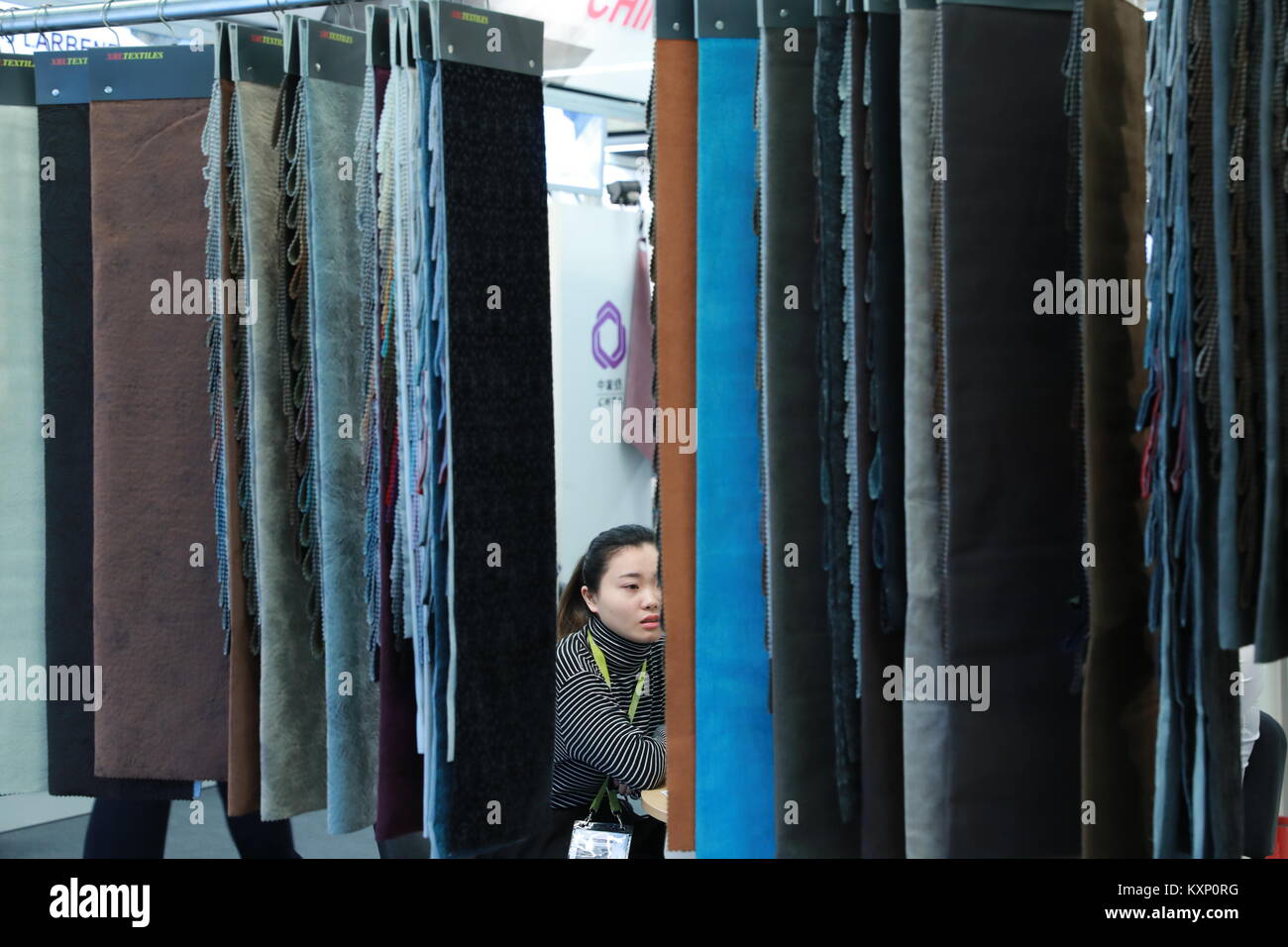 Frankfurt, Germany. 11th Jan, 2018. A worker sits at a Chinese textile booth at Heimtextil, the world's largest international trade fair for home and contract textiles, in Frankfurt, Germany, on Jan. 11, 2018. A total of 2,975 exhibitors from 64 countries and regions attended the trade fair this year, 545 of which are from China. Credit: Luo Huanhuan/Xinhua/Alamy Live News Stock Photo