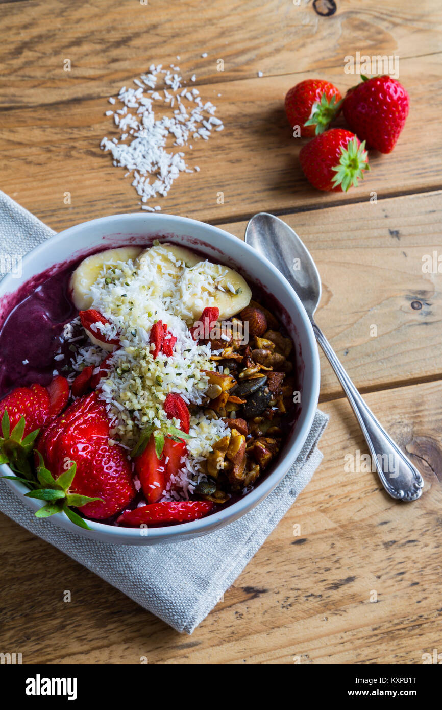 Acai bowl with spoon and ingredients Bowl of acai purée with toppings