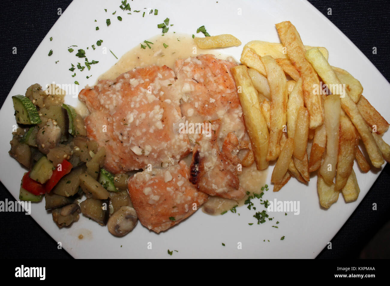 Peruvian cuisine ' Trucha - trout with garlic, chips and vegetables' Stock Photo