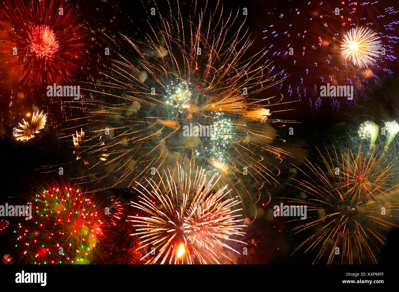 Realistic Fireworks exploding with clouds of smoke in the night sky - bright festive background. Stock Photo