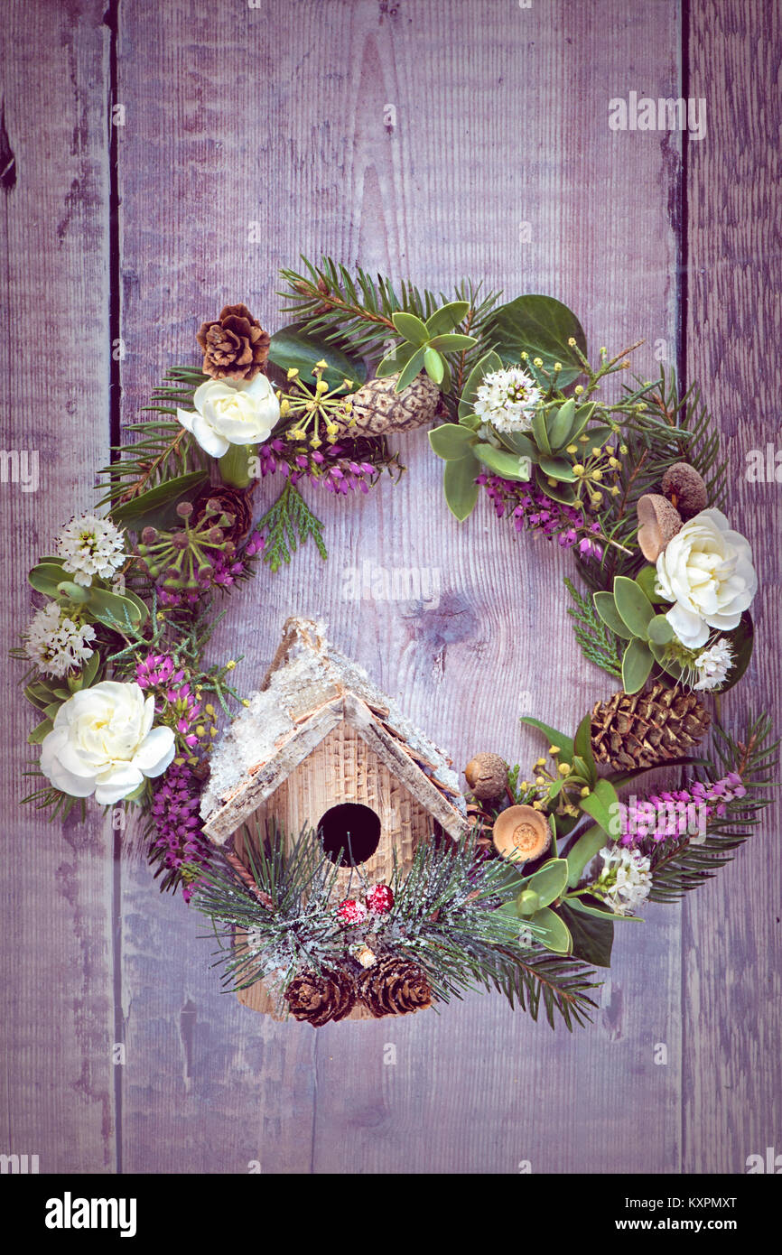 Close-up image of a festive, Christmas door wreath with little bird house attached. Stock Photo