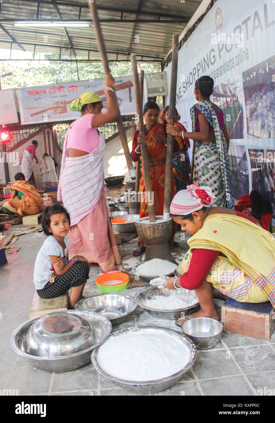 Assamese women busy making grain rice flour (Pithaguri) in Traditional