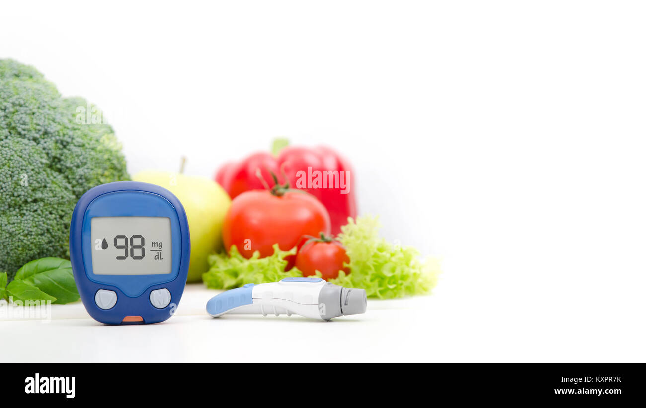 Glucometer and lancelet on vegetables background Stock Photo