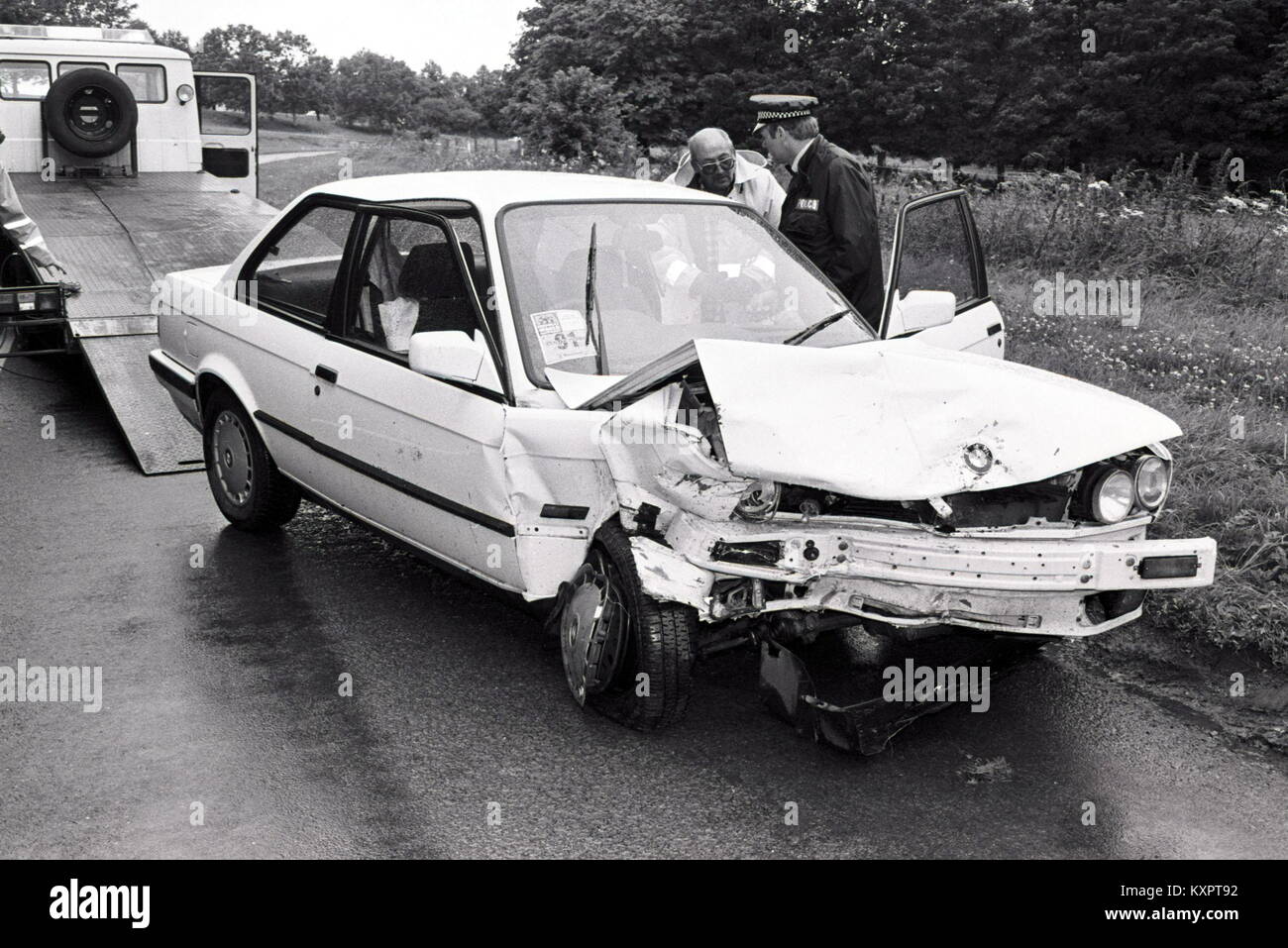 A crashed White 1988 BMW 3 Series is prepared for towing following an ...