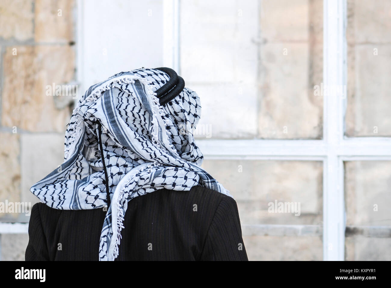 Horizontal picture of from back of man using Keffiyeh, traditional Middle  Eastern headdress fashioned from a square scarf, usually made of cotton  Stock Photo - Alamy