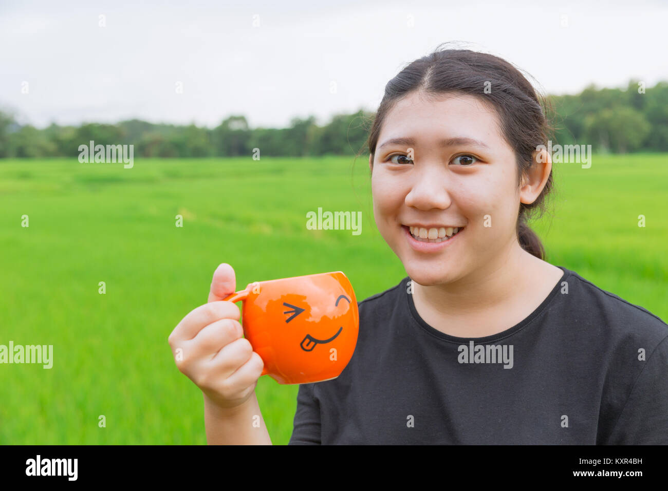 Asian Teen fat women hold mug with green nature background fresh nature healthy drink concept Stock Photo