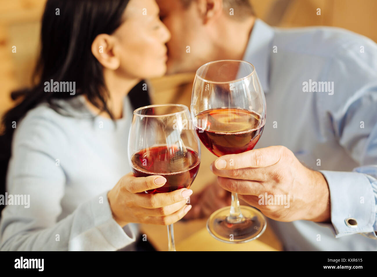 Sweet couple kissing and drinking wine Stock Photo