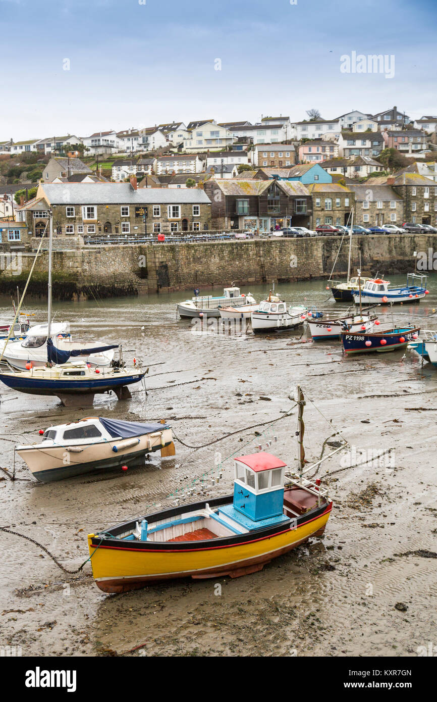 A colourful assortment of boats and yachts in Porthleven harbour at low tide on the south coast of Cornwall, England, UK Stock Photo