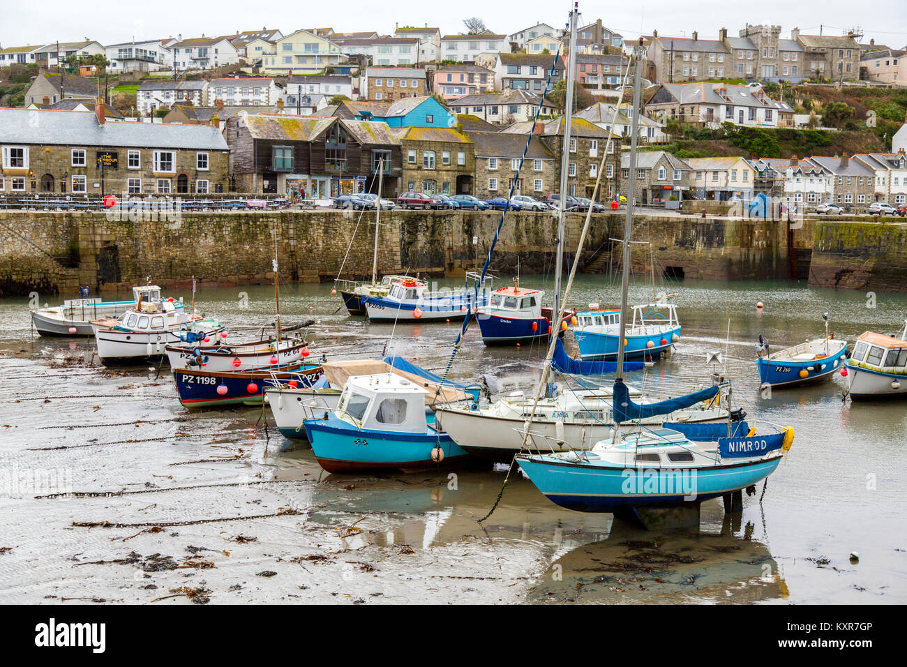 A colourful assortment of boats and yachts in Porthleven harbour at low tide on the south coast