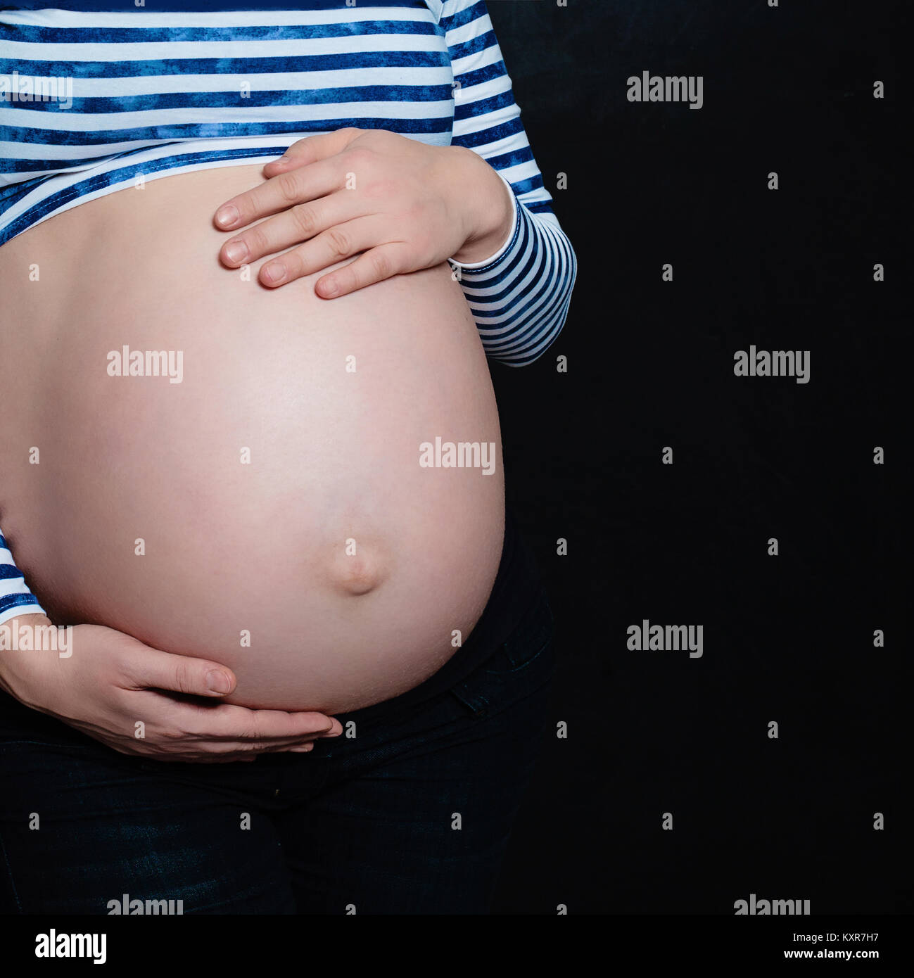 Belly of the Pregnant Mother on Black Background with Copyspace for Text Stock Photo