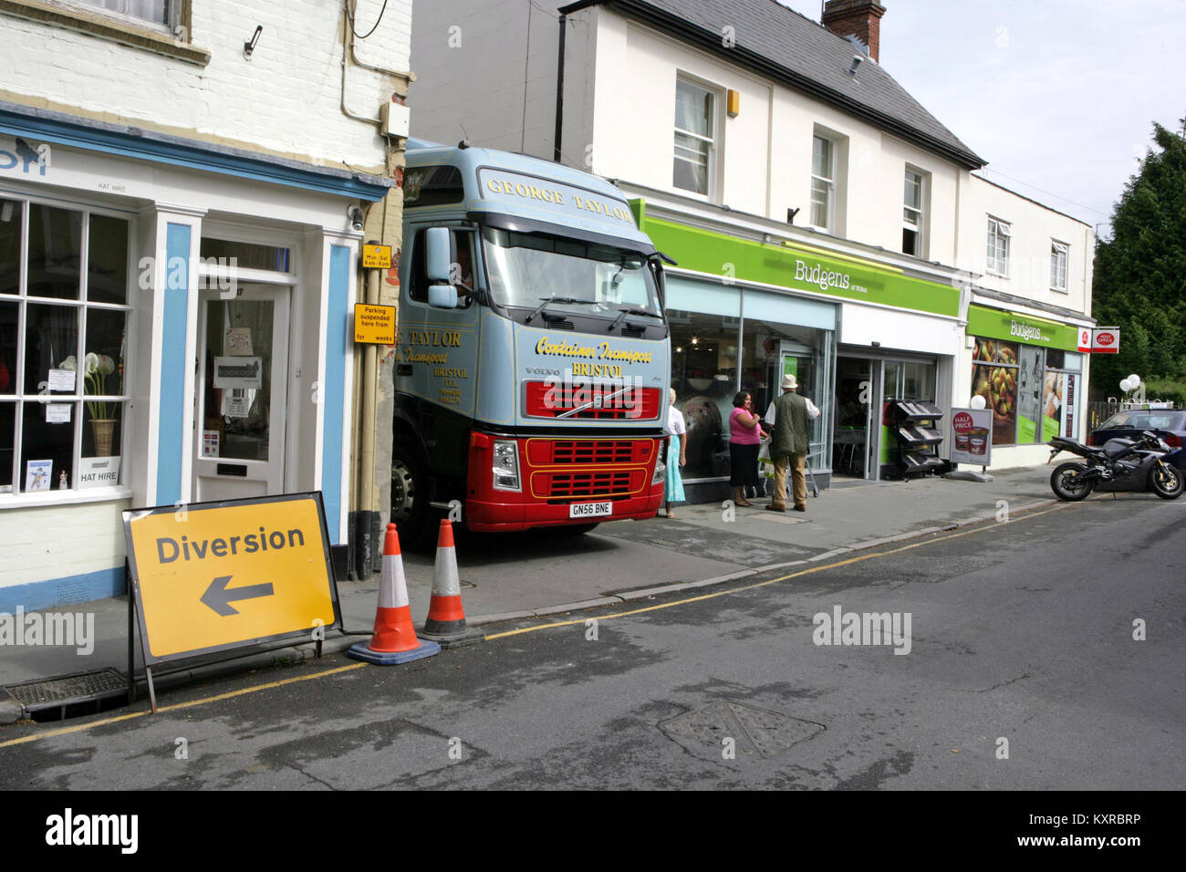 A Heavy Goods Vehicle squeezes through a narrow lane to follow a diversion route in Wilton, Wiltshire UK. Circa 2012. Stock Photo
