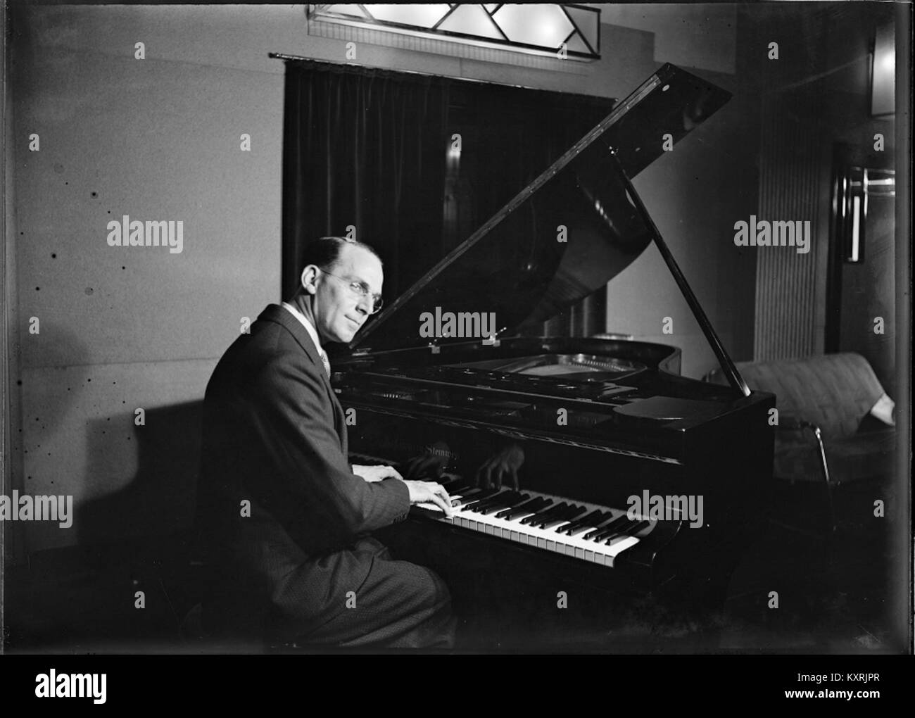 This photograph shows musician Ces Morrison seated at a grand piano in ...