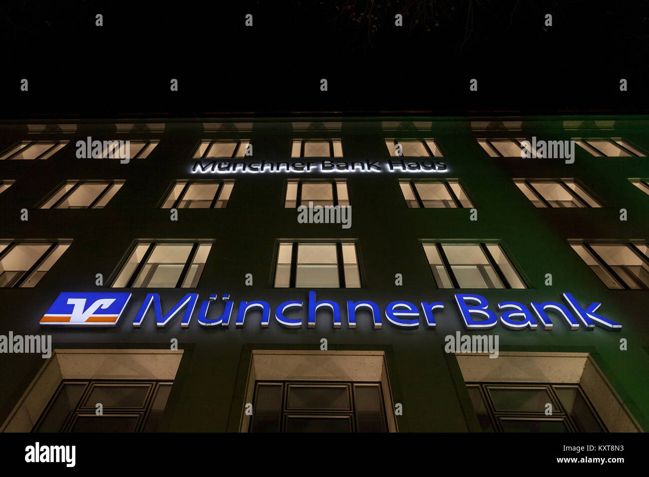 MUNICH, GERMANY - DECEMBER 17, 2017: Munchner Bank logo on their Munich main office (Munchner Bank Haus) taken at night. Munchner Bank (Bank of Munich Stock Photo