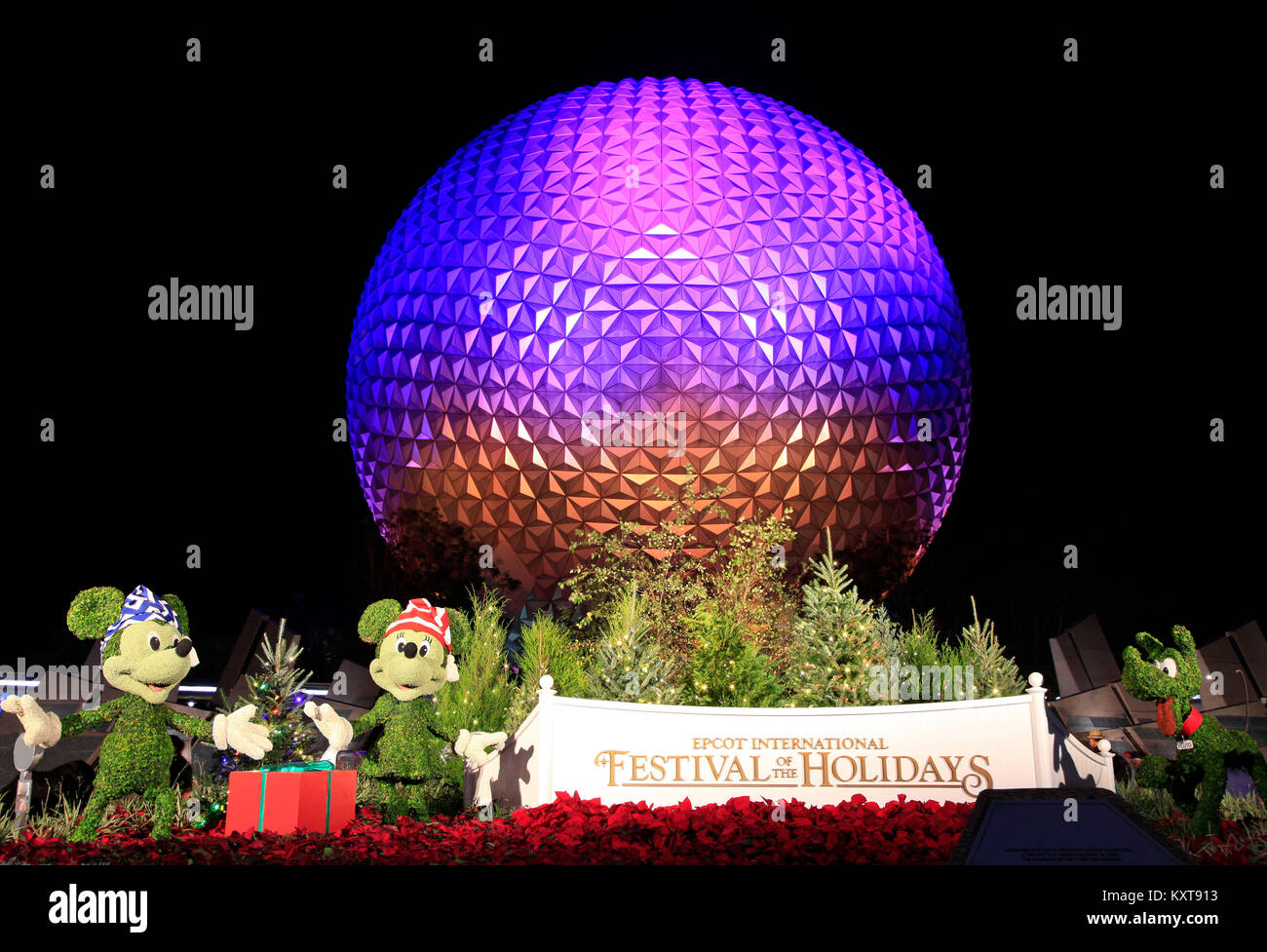 Disney's EPCOT Center sphere illuminated at night during Holidays Season with Mickey Mouse, Minnie and Pluto characters grass sculptures . Stock Photo