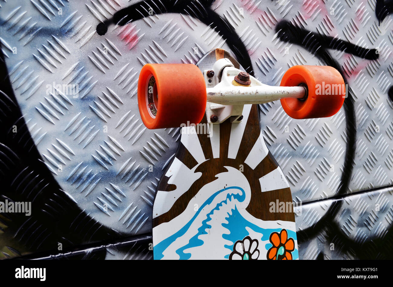 Longboard skateboard leaning against wall with graffiti Stock Photo Alamy