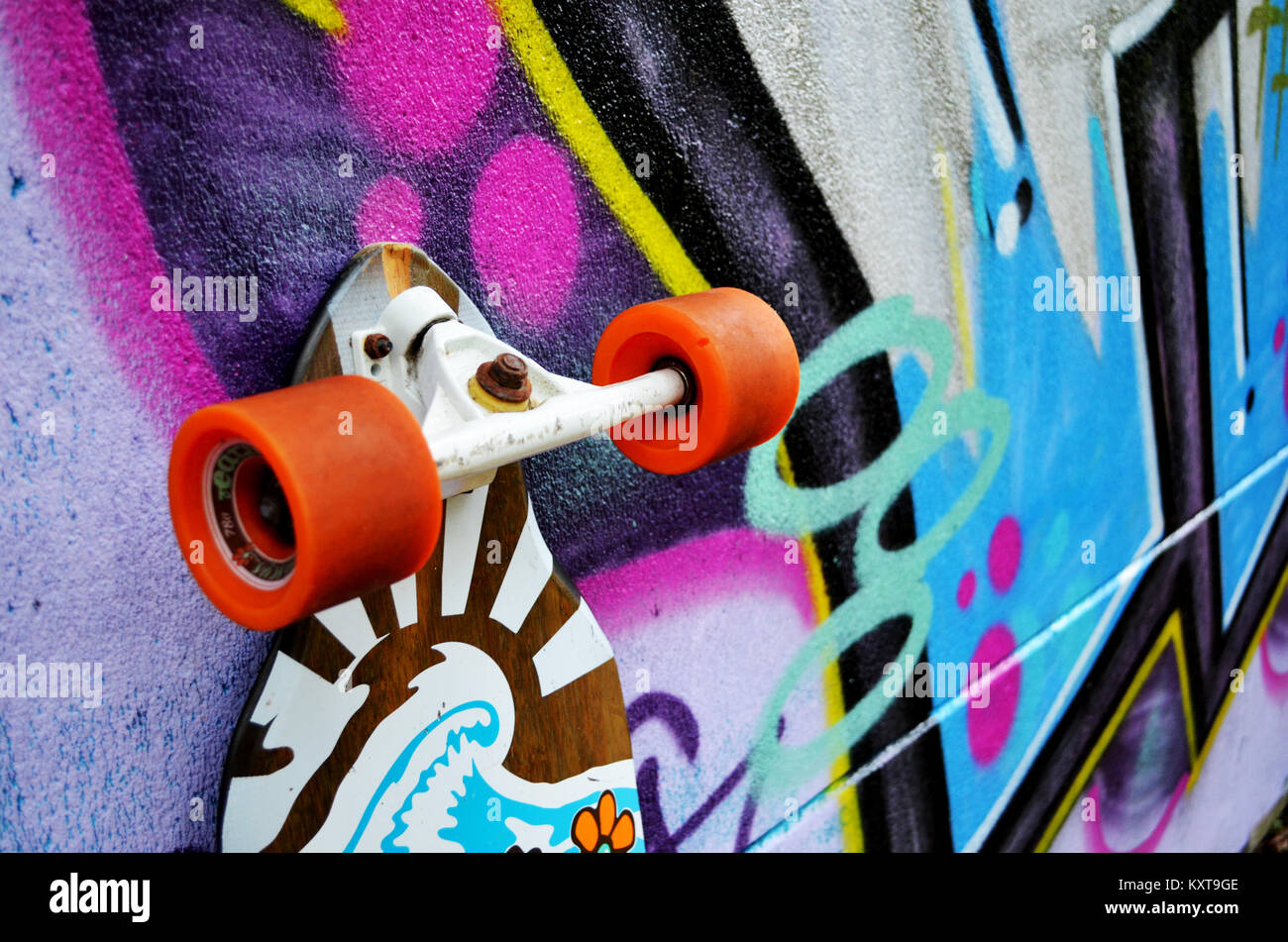 Longboard skateboard leaning against wall with graffiti Stock Photo Alamy